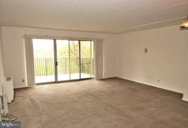 carpeted spare room featuring radiator heating unit