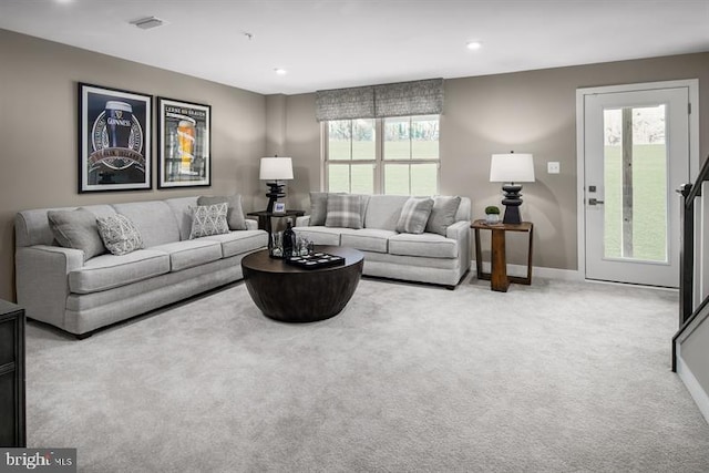 living room featuring light colored carpet and a healthy amount of sunlight