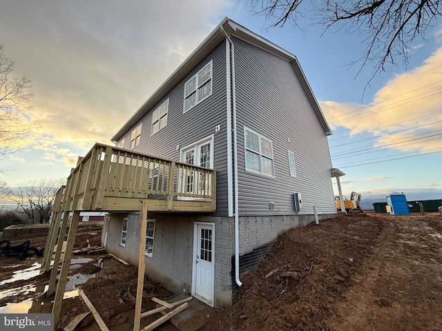 back house at dusk featuring a deck