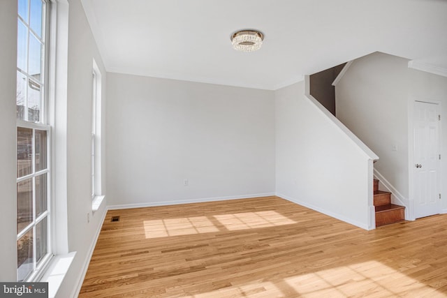 unfurnished living room featuring crown molding and light hardwood / wood-style floors