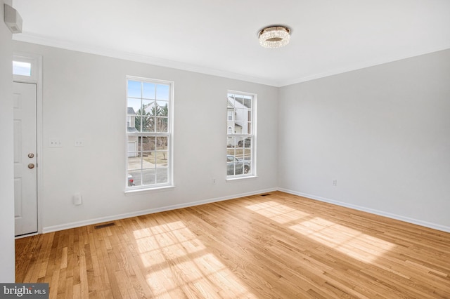 spare room with crown molding and light hardwood / wood-style floors