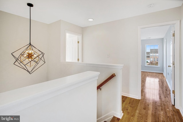 hall featuring hardwood / wood-style floors and a notable chandelier