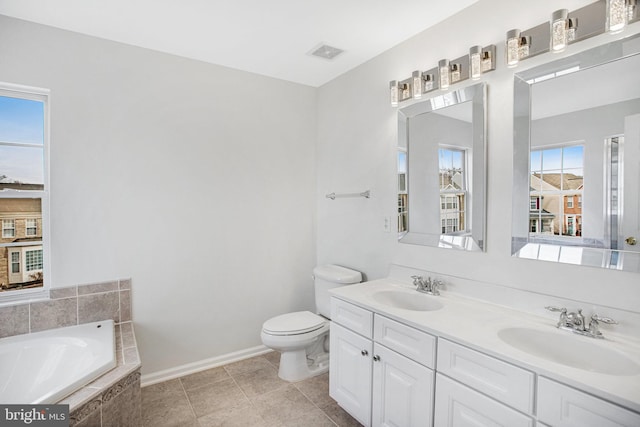 bathroom featuring vanity, tile patterned flooring, tiled bath, and toilet