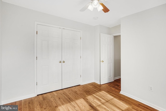 unfurnished bedroom with light hardwood / wood-style flooring, a closet, and ceiling fan