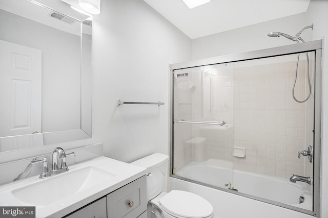 full bathroom with enclosed tub / shower combo, vanity, and toilet