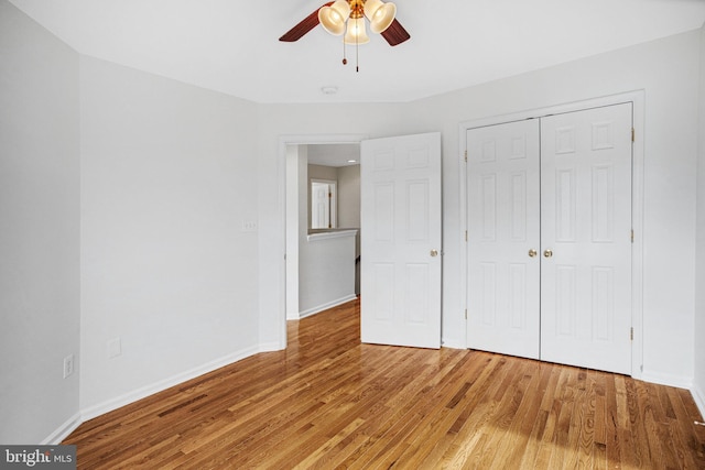 unfurnished bedroom featuring hardwood / wood-style flooring, ceiling fan, and a closet