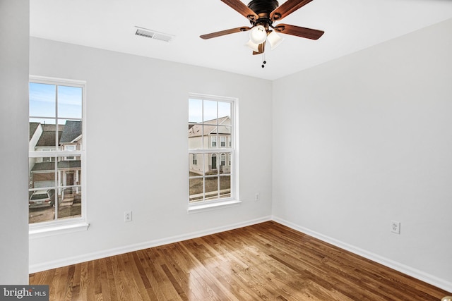 empty room with ceiling fan and hardwood / wood-style floors