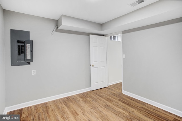 basement featuring electric panel and light wood-type flooring