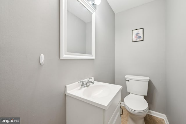 bathroom featuring tile patterned flooring, vanity, and toilet