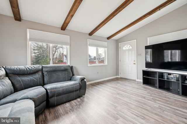 living room with vaulted ceiling with beams and light wood-type flooring