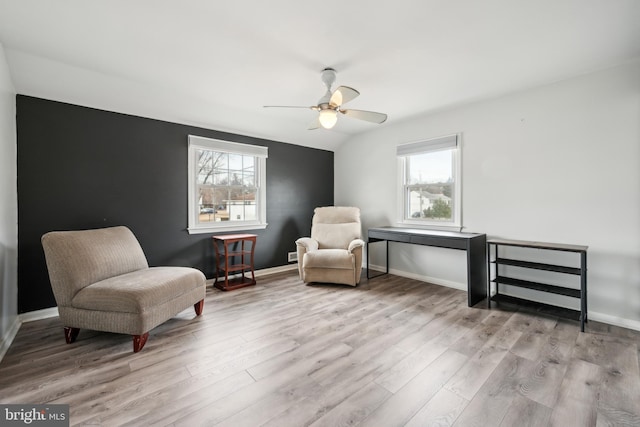 living area featuring ceiling fan, vaulted ceiling, light hardwood / wood-style flooring, and a wealth of natural light