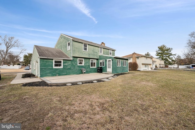 back of property with a yard and a patio area