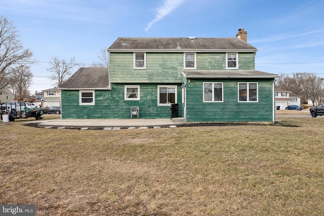 back of house with a lawn and a patio