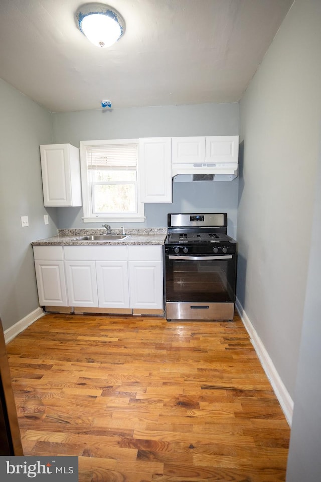 kitchen featuring white cabinetry, sink, light wood-type flooring, and stainless steel gas stove