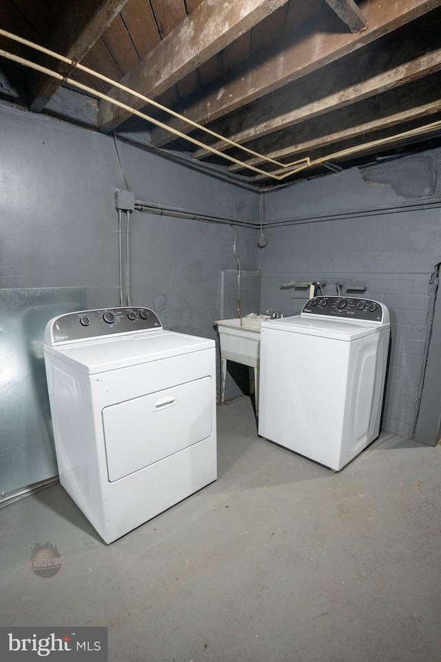 clothes washing area with separate washer and dryer and sink