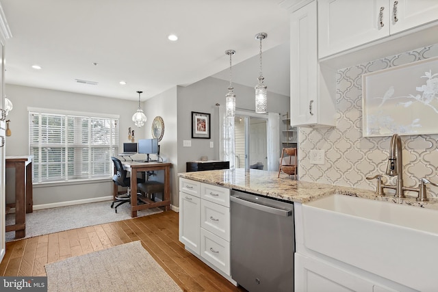 kitchen with sink, white cabinets, stainless steel dishwasher, light stone counters, and light wood-type flooring