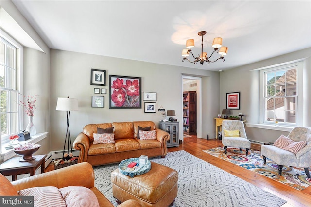 living room featuring hardwood / wood-style flooring, a healthy amount of sunlight, and a chandelier