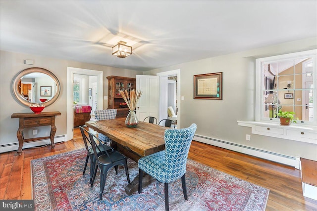 dining area featuring a baseboard heating unit and hardwood / wood-style floors