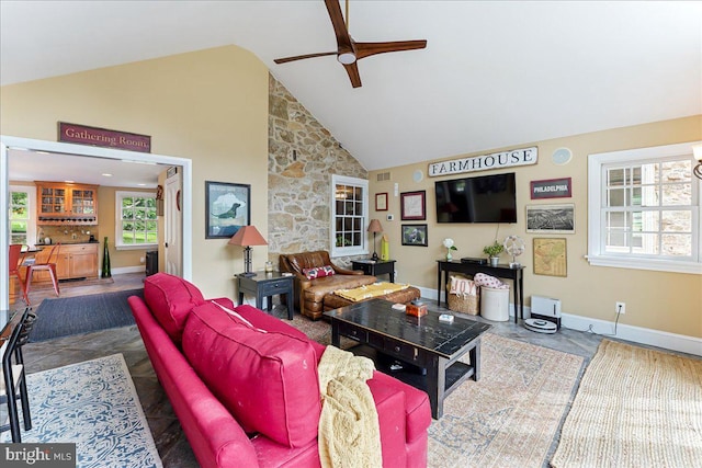 living room with ceiling fan and high vaulted ceiling