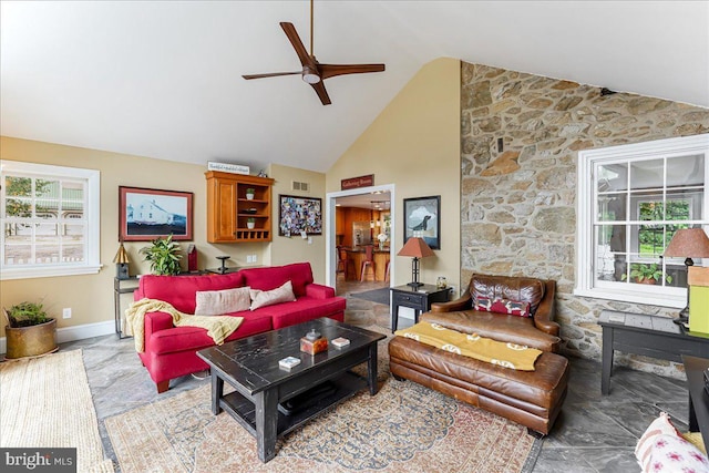 living room with ceiling fan, a healthy amount of sunlight, and high vaulted ceiling