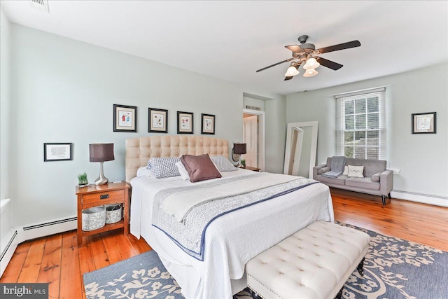 bedroom with hardwood / wood-style flooring, ceiling fan, and baseboard heating