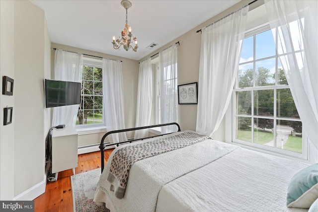 bedroom with wood-type flooring and a notable chandelier