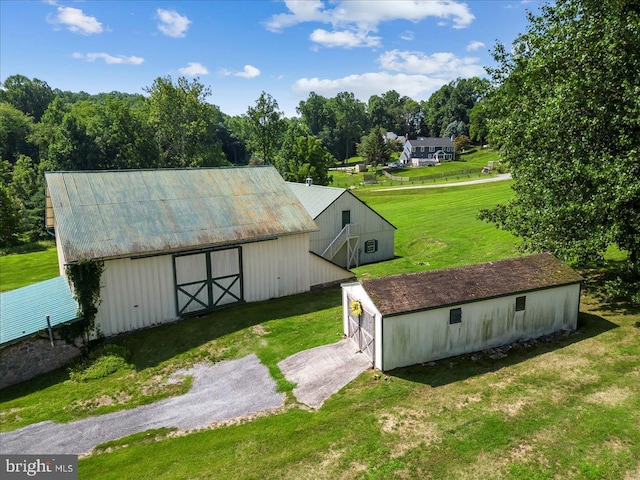 view of home's community with a garage, an outdoor structure, and a yard