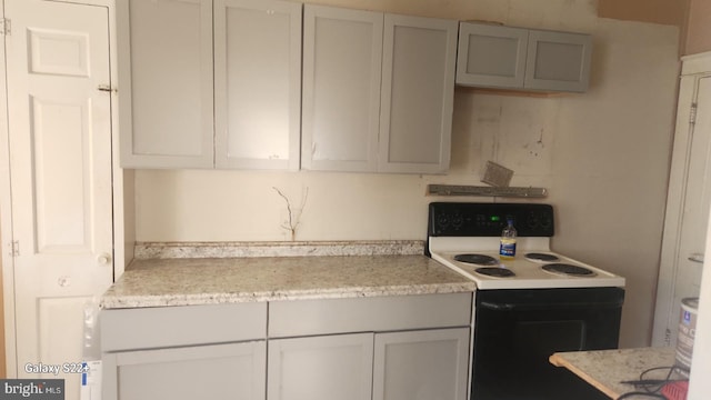 kitchen featuring light stone counters and electric range oven