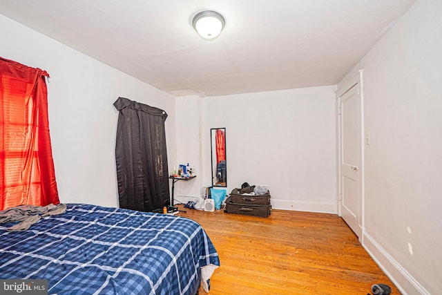 bedroom with wood finished floors and baseboards