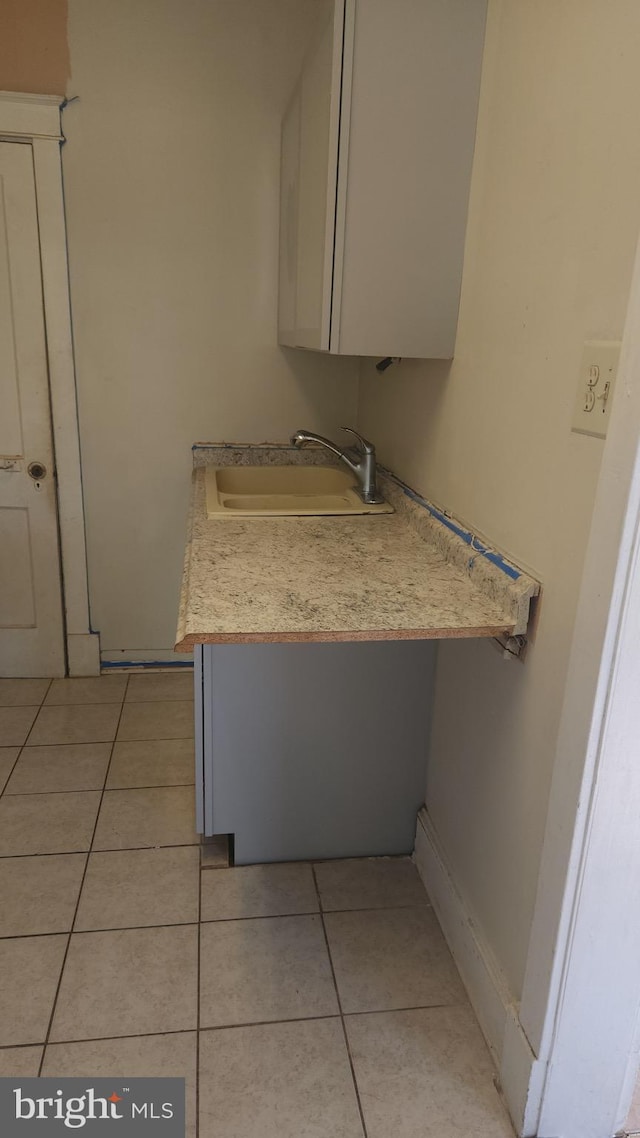 kitchen with light countertops, a sink, and light tile patterned flooring