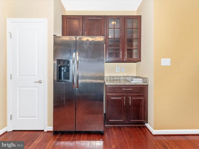 kitchen featuring stainless steel refrigerator with ice dispenser, light stone counters, and dark hardwood / wood-style flooring