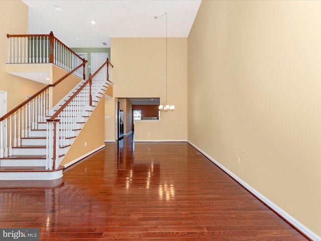 interior space featuring an inviting chandelier, hardwood / wood-style floors, and a towering ceiling