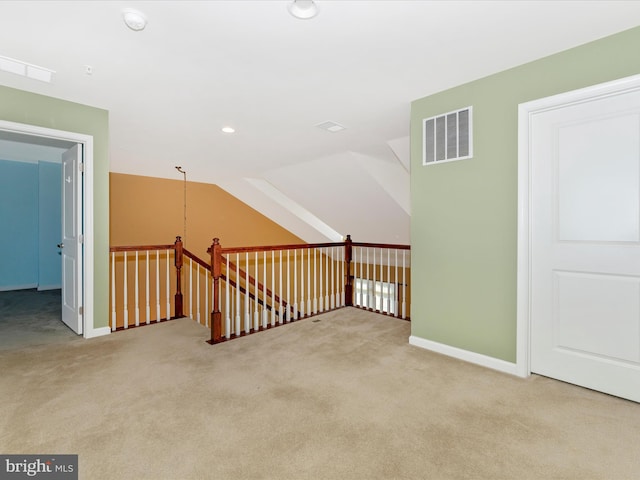 additional living space with vaulted ceiling and light colored carpet