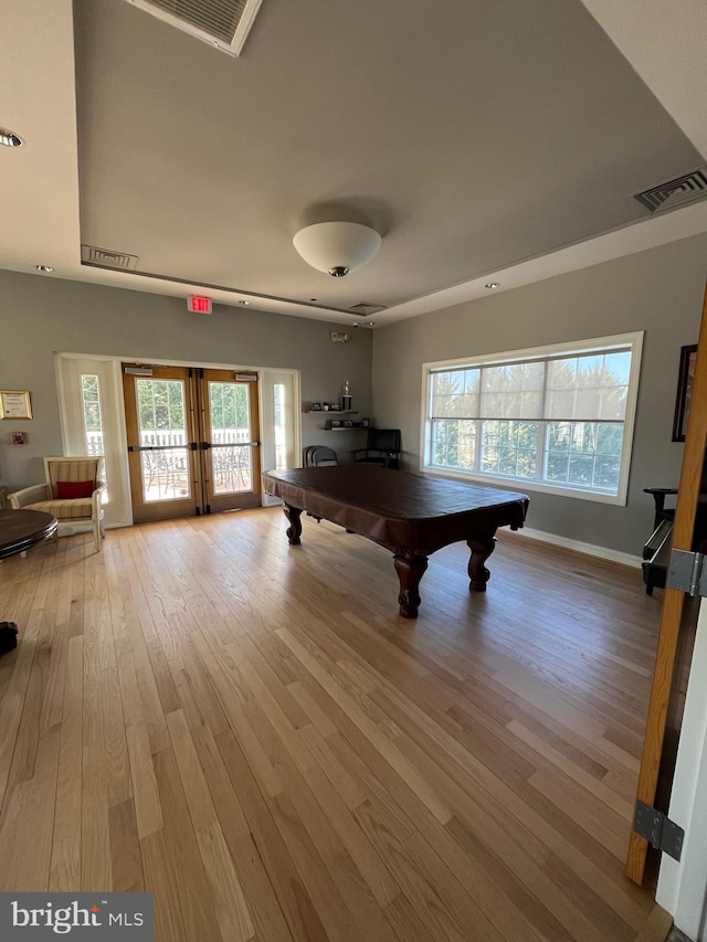 rec room with plenty of natural light, hardwood / wood-style floors, pool table, and french doors