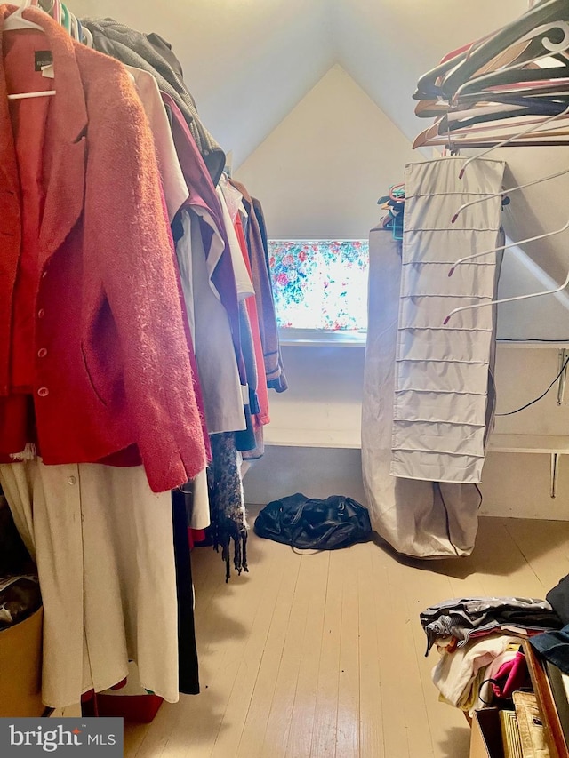 spacious closet with lofted ceiling and hardwood / wood-style floors