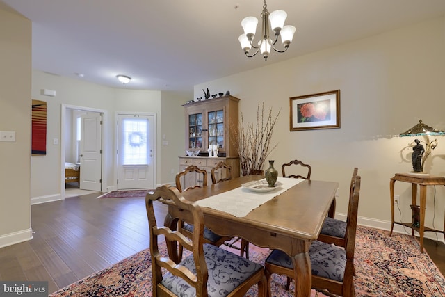 dining area featuring dark hardwood / wood-style floors and a chandelier