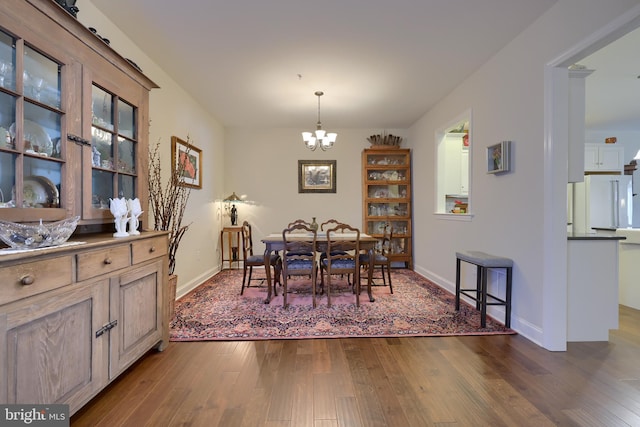 dining space featuring dark wood-type flooring and a chandelier