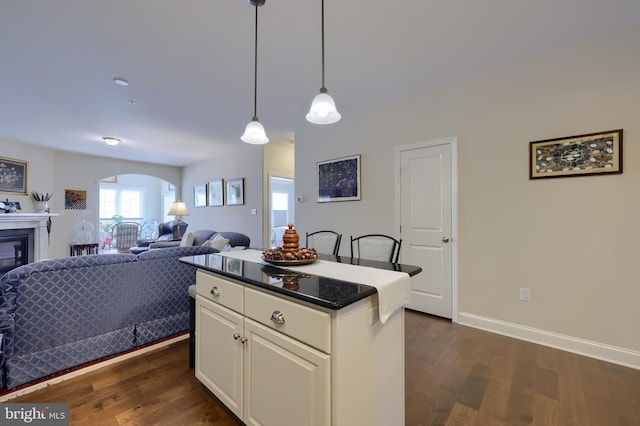 kitchen featuring pendant lighting, white cabinetry, dark hardwood / wood-style flooring, and a kitchen island