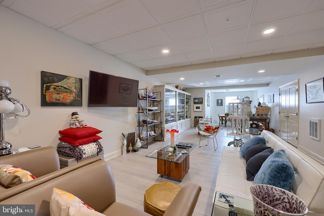 living room with light hardwood / wood-style floors and a drop ceiling