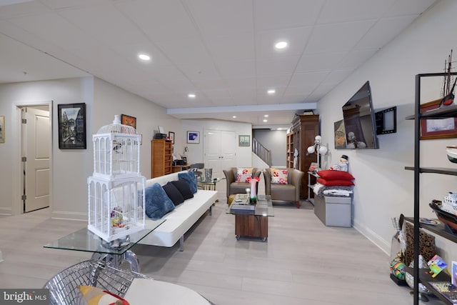 living room featuring light hardwood / wood-style flooring and a paneled ceiling