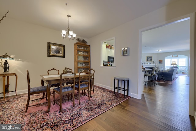 dining area featuring dark wood-type flooring and a notable chandelier