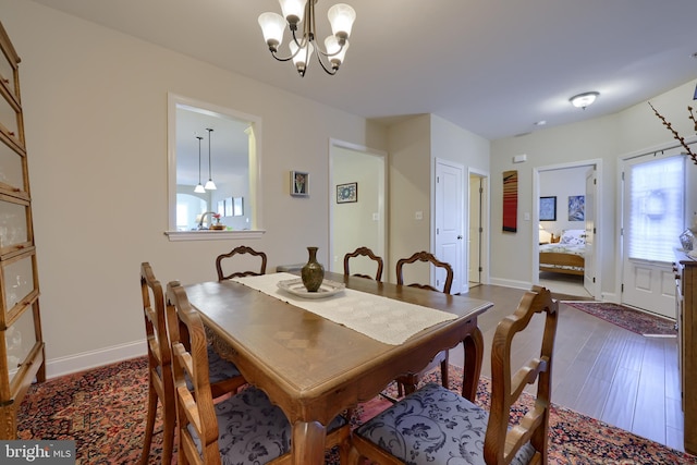 dining room with a notable chandelier, plenty of natural light, and dark hardwood / wood-style floors