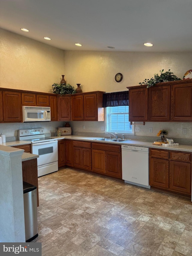 kitchen with tasteful backsplash, white appliances, and sink