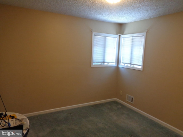 carpeted spare room featuring a textured ceiling