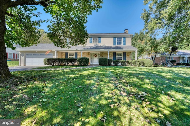 view of front of property with a garage, a porch, and a front yard