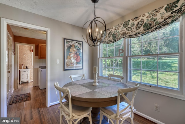 dining space with washer / clothes dryer, a textured ceiling, a notable chandelier, and dark hardwood / wood-style flooring