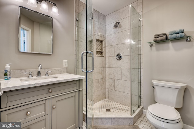 bathroom featuring an enclosed shower, vanity, and toilet