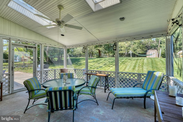 sunroom / solarium featuring ceiling fan and lofted ceiling with skylight