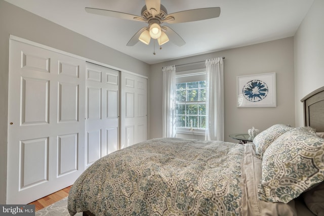 bedroom with ceiling fan, wood-type flooring, and a closet