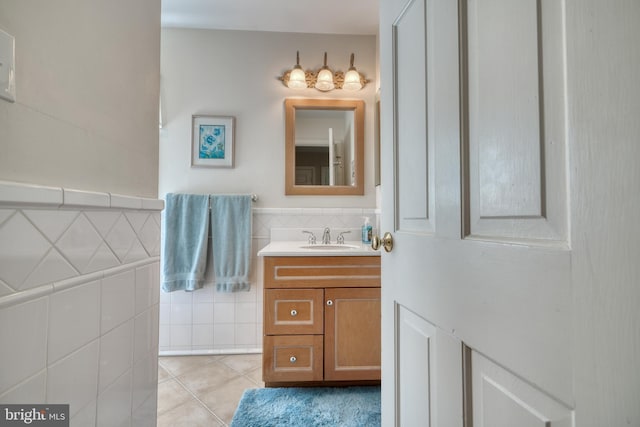 bathroom featuring tile patterned flooring, vanity, and tile walls